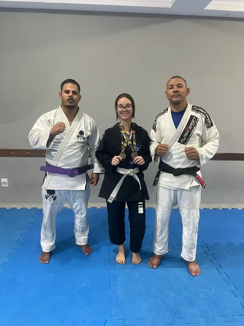 Aluna da academia Gilson Batista com medalhas de campeonato de jiu-jitsu ao lado dos professores